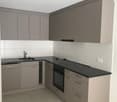 modern kitchen with gray cabinets, black countertops, stainless steel sink, gas stove, oven, dishwasher, power outlets, and tiled floor