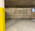 underground room, concrete walls, numbered yellow post, small window, tire marks