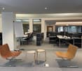 Open space office with desks, chairs, whiteboard, and natural light.