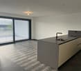 empty room, modern design, gray countertop, white cabinets, large windows, tiled floor