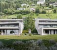 Modern two-story house, white exterior, large windows, glass balconies, green lawn, family playing in the yard