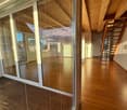 spacious empty room with sliding glass doors, wooden deck, wooden flooring, wooden beams