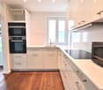 modern kitchen, white cabinets, black appliances, dishwasher, washing machine, windows