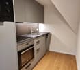 small kitchen with sink, microwave, stove, oven, dishwasher, refrigerator, wooden floor
