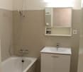 white bathtub, mirror, bathroom cabinet, faucet