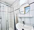 Bathroom, shower area, sink, mirror, soap dispenser, towel rack