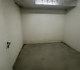 empty room, white walls, concrete floor, single light fixture