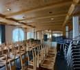 wooden chairs and tables, wooden beams, large windows, curtains, carpet