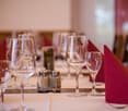 Table set for dining with wine glasses, red napkins, salt and pepper shakers, and forks