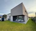 modern design house, two story, glass windows, large lawn, grey sofa set, solar panels, car parking