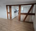 empty room, wooden beams, wooden floor, white kitchen, sink, black countertop, window