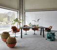 large open room with furniture and plants, concrete floor, glass doors, white wall