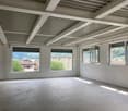 empty room, white walls, tiled floor, large windows, view of trees and buildings