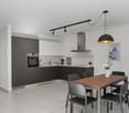 modern kitchen with appliances, dining table, gray chairs, white tile floor, artwork on wall, track lighting