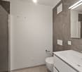 modern design, white tiled walls, gray tiles, shower stall, white toilet, sink with faucet, mirror
