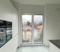 modern kitchen with white cabinets, black countertop, large sliding glass doors, oven, view of the outside