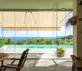 glass doors, wooden table, chairs, swimming pool, sea view