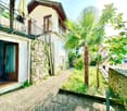 Stone wall, balcony, open door, palm tree, gravel path, stone wall