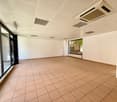 large empty room, white walls, tiled floor, large glass windows, ceiling mounted air conditioning