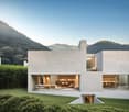Modern concrete house with multiple levels, large glass windows, open floor plan, balcony, kitchen island, dining area, living area