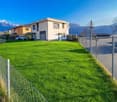 Detached house, modern architecture, fenced lawn, mountains in background