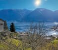 House on a hill with a view of the mountains and the lake