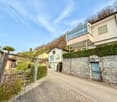 Houses on a hill, stone wall, brick road, hedges, clear sky