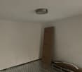 Empty room, white walls, ceiling, grey floor, ceiling light, cardboard box