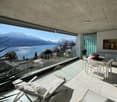 modern terrace with glass railings, white furniture, lake view, white tiled floor