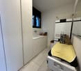 Laundry room with washing machine, dishwasher, sink, cabinets, and a window