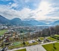 Aerial view of a city with mountains, buildings, and a green field