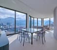 modern dining area with large windows, glass table, modern chairs, couch, city view