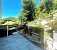 glass railing, tiled floor, plants, greenery, distant mountain view