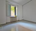 empty room, white walls, white floor, window with shutters, radiator, window sill with box