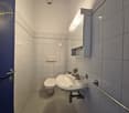 small bathroom with toilet, sink, and mirror