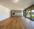 modern kitchen with white cabinets, wooden floors, large glass sliding doors leading to terrace, panoramic mountain view