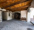 wooden beams, stone walls, bench, arched entryway, cobblestone floor