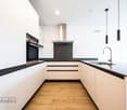 modern design, white cabinets, black countertops, stainless steel appliances, wooden floor