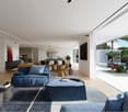 Spacious open-concept living room with large windows overlooking an outdoor garden and pool area. The room features a blue sectional sofa, a round gold coffee table, and a black entertainment unit. The decor has a modern and minimalist style with a mix of