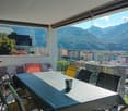 covered terrace with large table, mountain view, town view, furniture on terrace