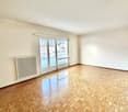 large room, wooden parquet floor, white walls, sliding glass doors, balcony, white radiator