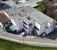 Three story building, concrete exterior, 2 parking places in front, spiral staircase on the back
