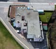 2 story house, multiple windows, flat roof, large car parking area in front, 2 garages
