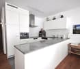 white cabinetry, granite countertop, stainless steel appliances, modern decor, wooden floor