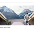 balcony, man, table, chairs, plants, glass walls, mountains in background