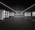 Empty car parking area with dark walls and ground, and LED lighting on the ceiling