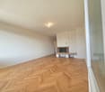 Empty room, wooden parquet floor, white walls, fireplace, large window, open doorway