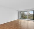 empty room, white walls, wooden floor, sliding glass doors to balcony