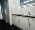 white cabinets, tiled flooring, gas stove, single sink, no windows, electrical outlet