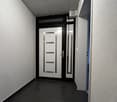 elevated ground floor, minimalist corridor, white walls, gray floor, main entrance door, hallway